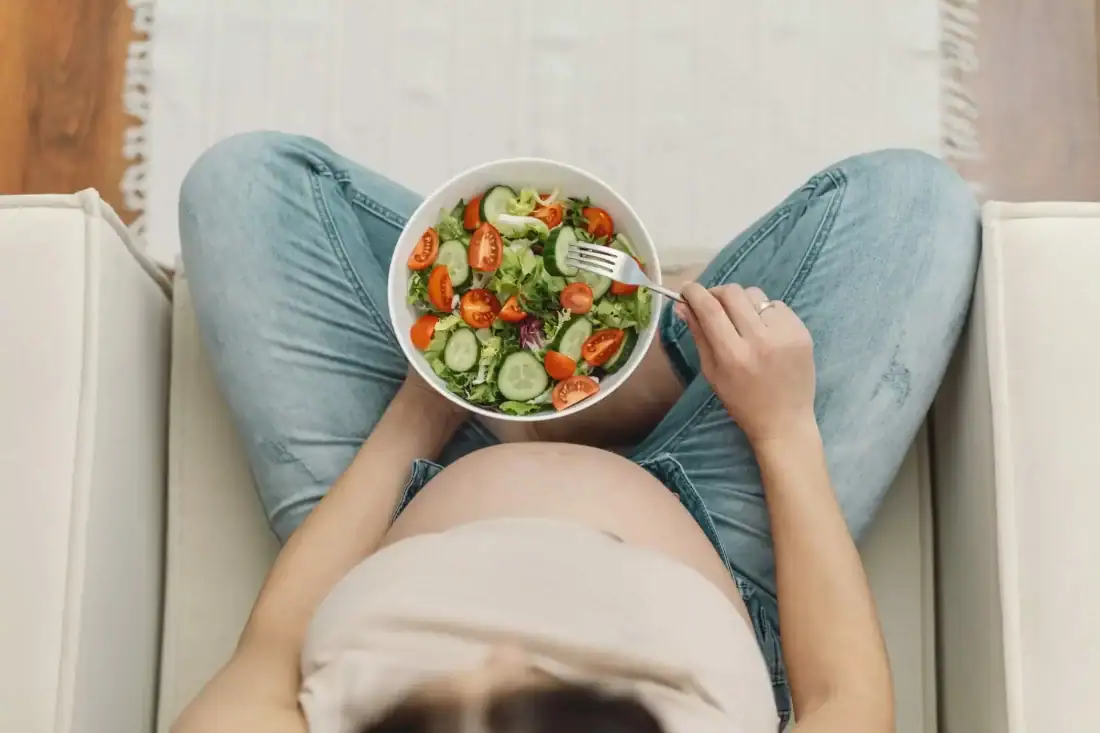 Healthy woman eats salad with vegetables, focus on nutritional advice and healthy eating.